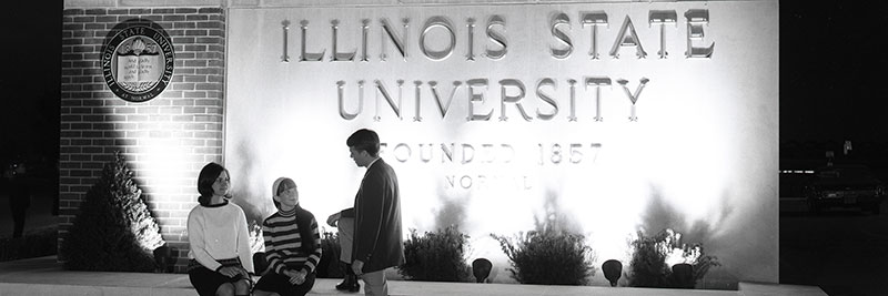 Students talking in front of ISU sign.