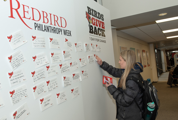 student writing note on wall of thank yous