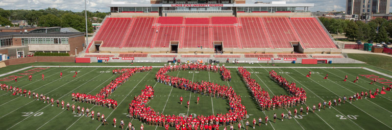 Students stand in position to form 'ISU' on the football field in Hancock Stadium.